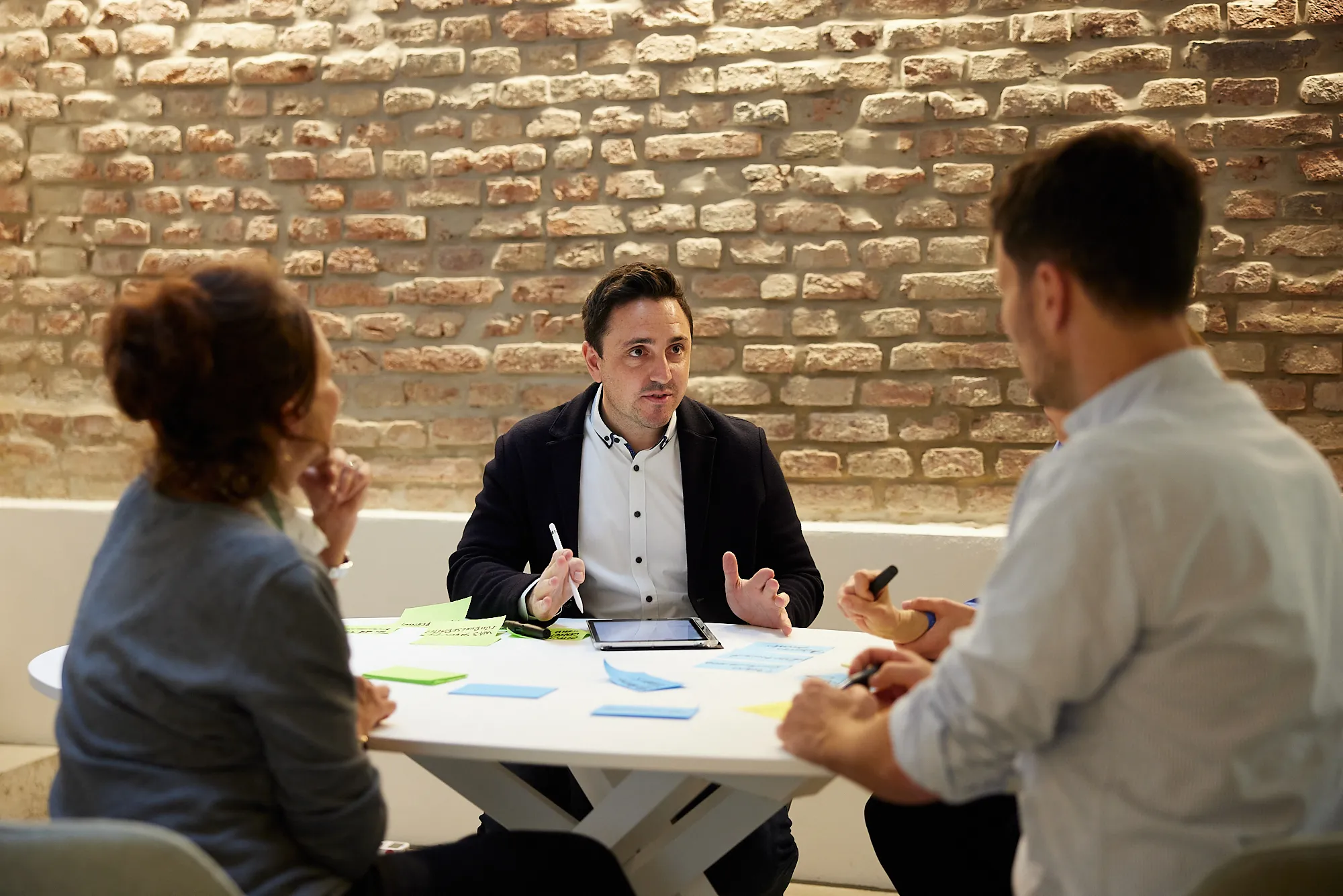 Berater spricht mit zwei Personen im Workshop zu Change Management Consulting und Change Coaching