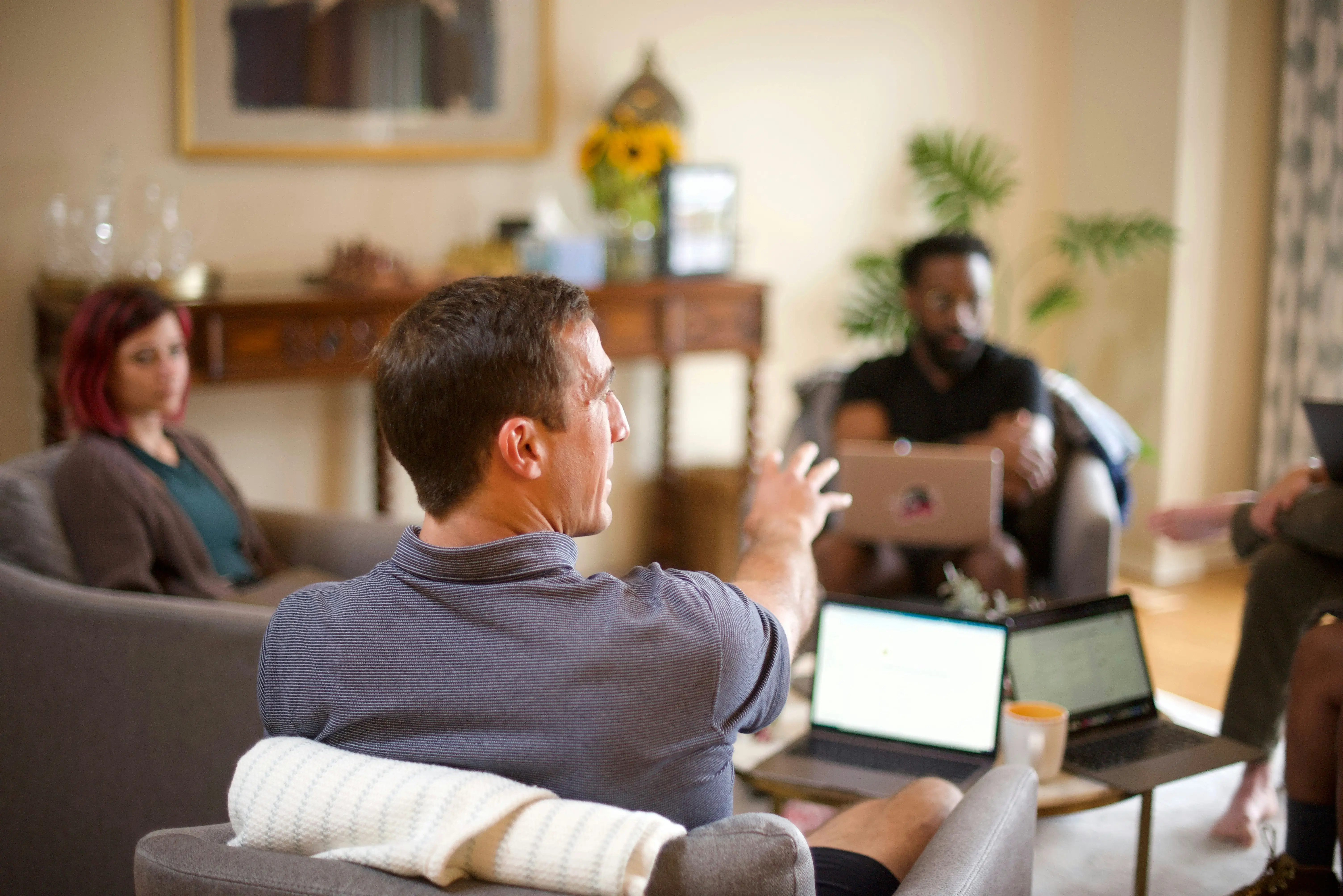 Gruppe sitzt vor Laptops und kommuniziert